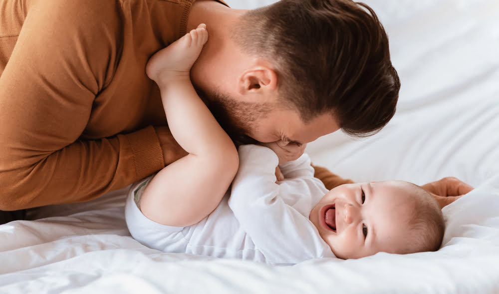 Vater spielt und lacht mit seinem Baby